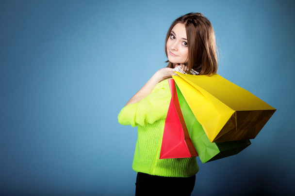 young woman with paper multi coloured shopping bag - Foto, afbeelding