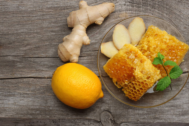 healthy background. honey, honeycomb, lemon, ginger on old wooden table. Top view with copy space - Foto, immagini