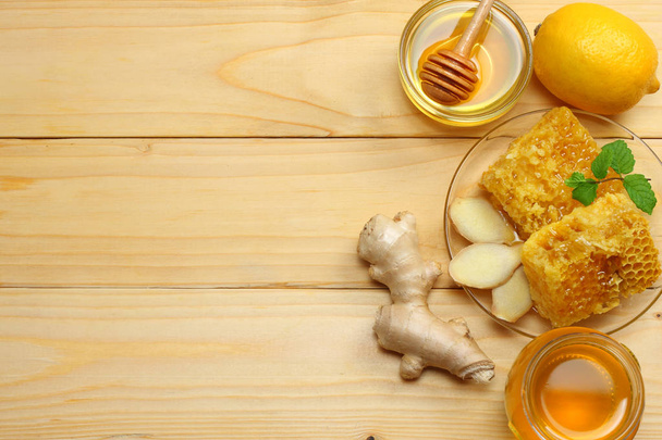 healthy background. honey, honeycomb, lemon, tea, ginger on light wooden table. Top view with copy space - Fotoğraf, Görsel