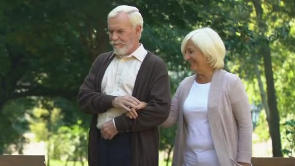 Elder couple hugging and walking at summer park, enjoying pastime together - Materiał filmowy, wideo