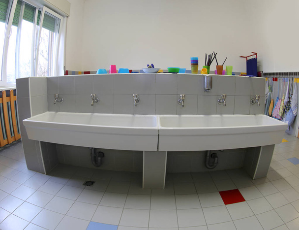 łazienka z długim umywalki do mycia wnętrza przedszkola bez dzieci - Zdjęcie, obraz