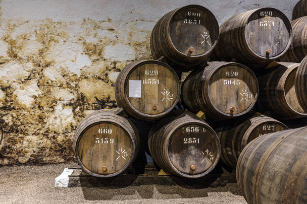 Row of wooden Porto wine barrels in wine cellar Porto, Portugal. - 写真・画像