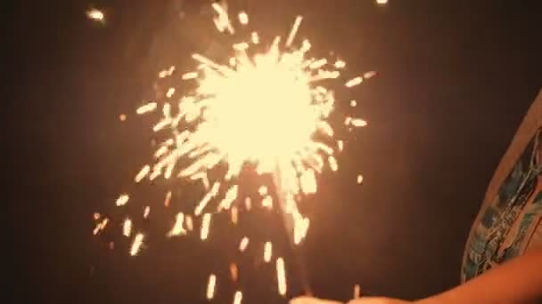 Mujer hoilding quemando luces de bengala en su mano
 - Metraje, vídeo