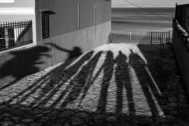 Sombras de tarde longas de sete pessoas e Mar
 - Foto, Imagem