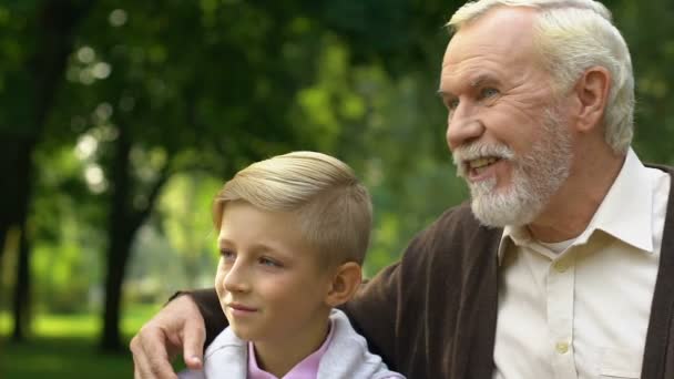 Дедушка показывает внуку что-то в парке, наслаждается свободным временем вместе.
 - Кадры, видео