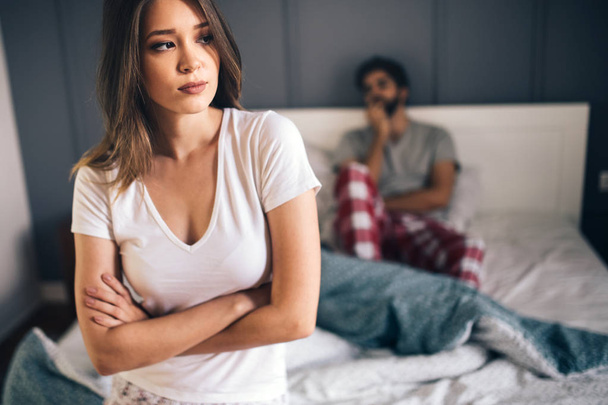 Young couple having arguments and sexual problems in bed - Foto, afbeelding
