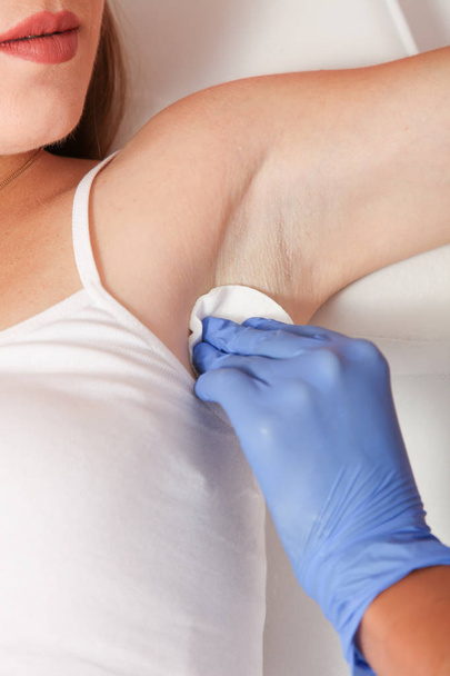 Preparing for epilation woman's armpit, on white couch. - Foto, Bild