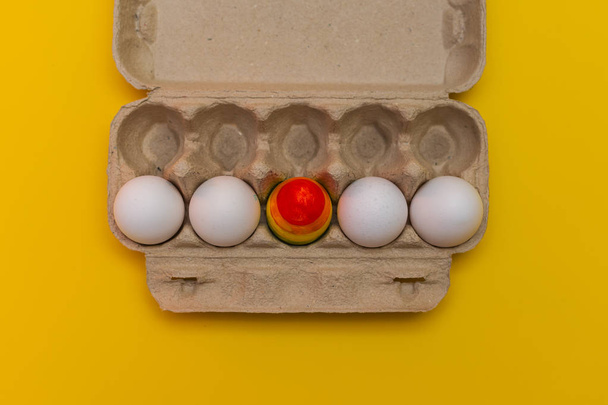 jedno barevné vejce v balíčku obyčejných bílých vajec. koncept Lgbt - Fotografie, Obrázek