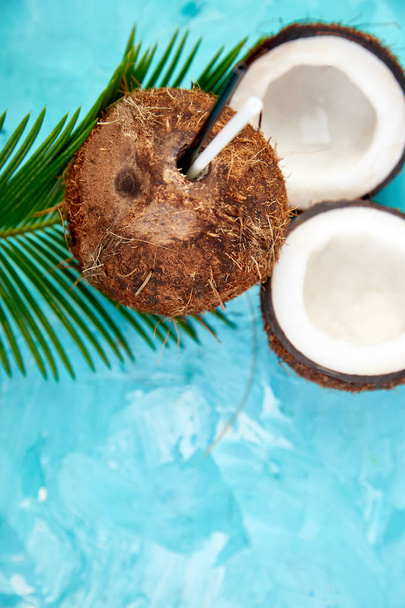 ココナッツは、青色の背景色のカクテル。夏の休日は、ココナッツのコンセプト、トロピカル ・ カクテルやジュースを飲みます。コピー スペース.  - 写真・画像