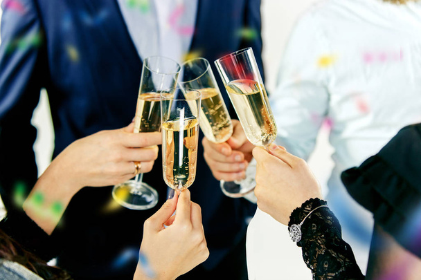 Feest. Handen die de glazen champagne en wijn vasthouden en een toast uitbrengen. - Foto, afbeelding