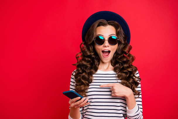 Portrait of nice funky childish attractive positive wavy-haired lady in striped pullover eyeglasses eyewear sunhat showing sms opened mouth isolated over bright vivid shine red background - Foto, immagini