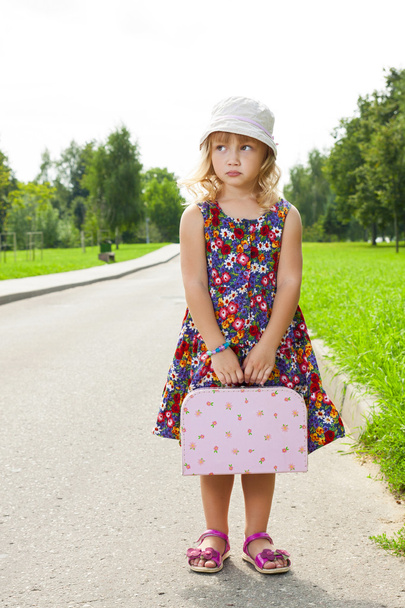 girl with suitcase standing on road - Valokuva, kuva