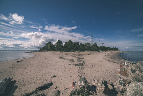 Strand mit Sanddünen und Felsen unter blauem Himmel - Foto, Bild