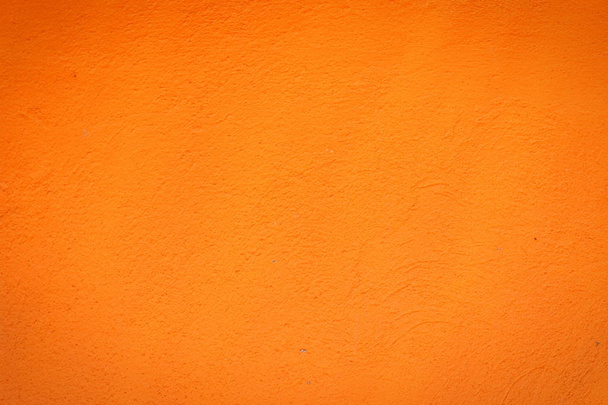Achtergrond van een oranje stucwerk bekleed en geschilderd buitenkant, ruwe cast van cement en betonnen muur textuur, decoratieve rustieke coating - Foto, afbeelding