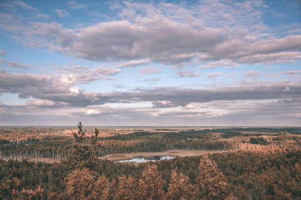 τοπίο του φθινοπώρου δέντρα και λίμνη στην ύπαιθρο κάτω από δραματικές ουρανό - Φωτογραφία, εικόνα