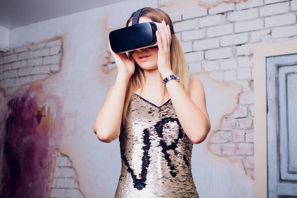 Cheerful girl with hands up wearing the virtual reality goggles. - 写真・画像