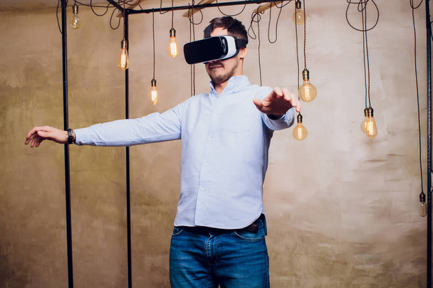 Amazed man looking in a VR goggles and gesturing. - Photo, Image