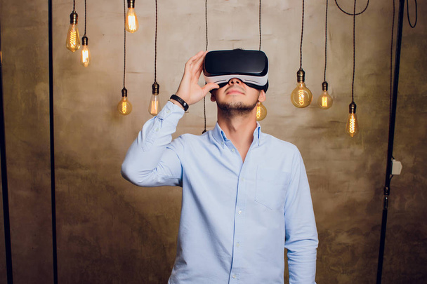 Amazed man looking in a VR goggles and gesturing. - Foto, Imagem