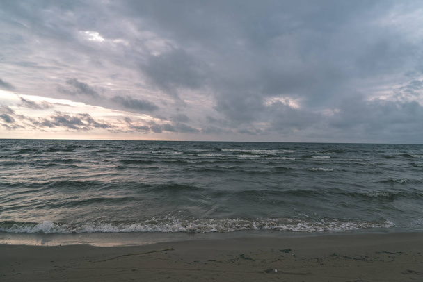 sötét tengervíz és a tengerpart viharos ég alatt - Fotó, kép