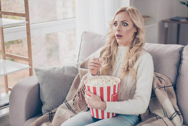 Portrait of nice attractive lovely stylish trendy funny stunned wavy-haired lady housewife in sweater sitting on divan eating fast food watching video in light interior room - Photo, Image