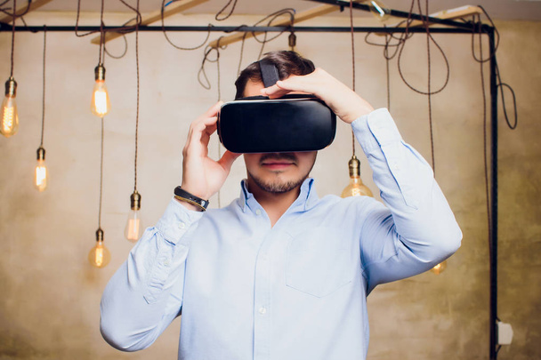 Amazed man looking in a VR goggles and gesturing. - Foto, imagen