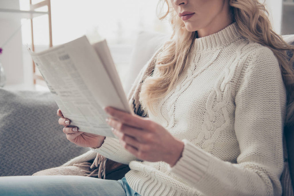 Cropped profile side view portrait of nice lovely attractive wavy-haired lady housewife wearing sweater holding in hands reading digest in light interior room - Foto, Imagem