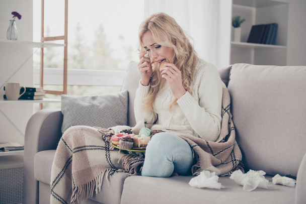 Portrait of nice lovely attractive gloomy wavy-haired lady in lotus pose crying eating large plate of tempting seductive homemade domestic baked sweets in light interior room - Foto, imagen