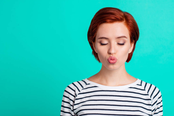 Close-up portrait of her she nice lovely sweet attractive adorable red-haired lady in striped pullover sending air kiss closed eyes isolated over bright vivid shine green turquoise background - Photo, Image
