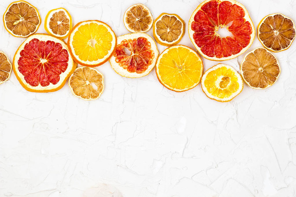 Erilaisten sitrushedelmien kuivattujen viipaleiden raja valkoisella taustalla. Monet Oranssi sitruuna greippi kanssa copyspace
 - Valokuva, kuva