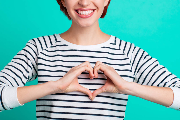 Cropped close up portrait of beautiful cute foxy she her lady fingers hands making figure form of heart really glad to have healthy heart wearing white striped pullover isolated on teal background - 写真・画像