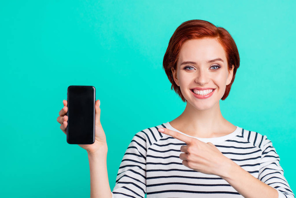 Close up portrait of cheerful attractive she her lady with telephone in hand new model of apple telephone just have look at price wearing white striped sweater isolated on teal background - Foto, Imagem