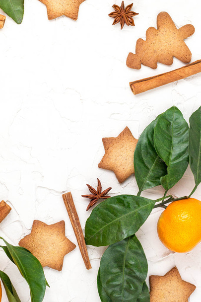 Rand von Weihnachtssternkeksen mit Gewürzen und Mandarine auf weißem Hintergrund mit Copyspace. Ansicht von oben - Foto, Bild