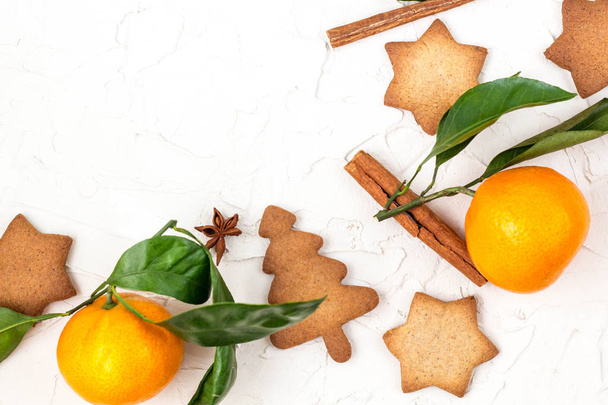 Határ a karácsonyi csillag a cookie-k fűszerek és a mandarin, a fehér háttér, copyspace. Szemközti nézet - Fotó, kép