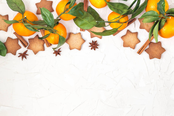 Galletas estrella de la frontera de Navidad con especias y mandarina sobre fondo blanco con copyspace. Vista superior
 - Foto, Imagen