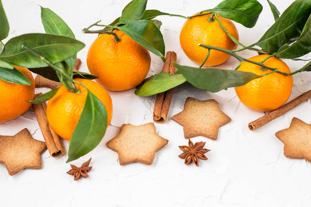 Weihnachtssternkekse mit Gewürzen und Mandarine auf weißem Hintergrund mit Copyspace. Ansicht von oben - Foto, Bild