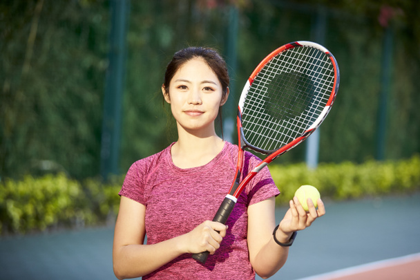 ritratto all'aperto di un giovane tennista asiatico che guarda la macchina fotografica sorridente
 - Foto, immagini