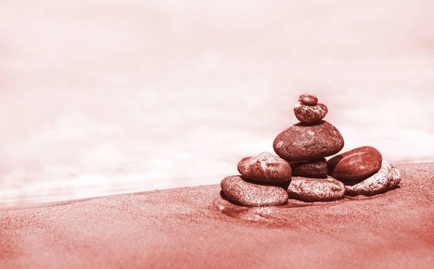 Hoop stenen tegen de zee met kopie ruimte. Afbeelding in trendy wonen koraal kleur - Foto, afbeelding