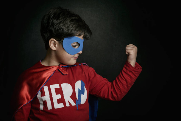 黒い背景にスーパー ヒーローの衣装を着た少年の肖像画 - 写真・画像