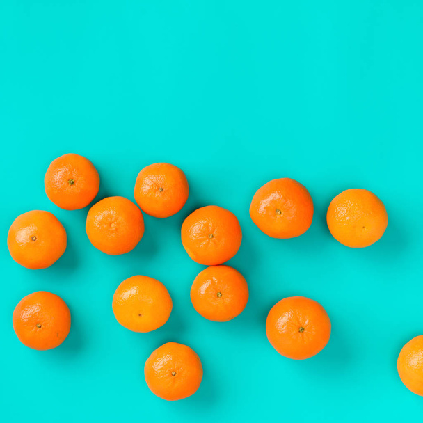 Fruit pattern of fresh mandarins on blue background. - Φωτογραφία, εικόνα