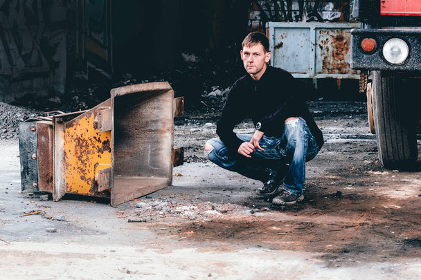 Portrait of young man sitting in in abandoned building - Photo, image