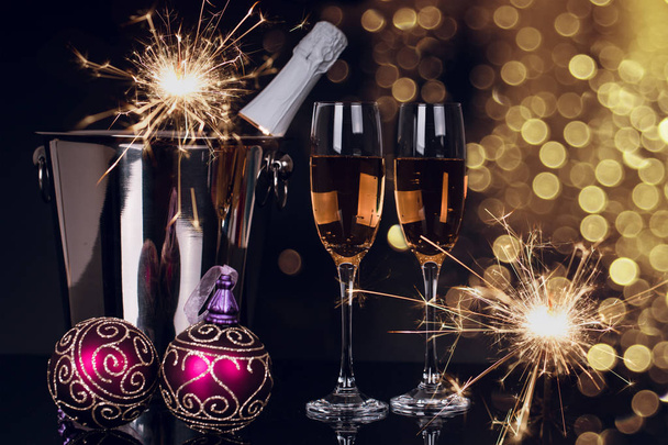 Dwa kieliszki do wina z Szampanii, butelka, ognie i ozdoby świąteczne na czarnym tle. Kopiować miejsca. Wesołych Świąt i szczęśliwego nowego roku, tło - Zdjęcie, obraz