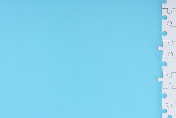 vista superior de piezas blancas del rompecabezas dispuestas sobre fondo azul
 - Foto, Imagen