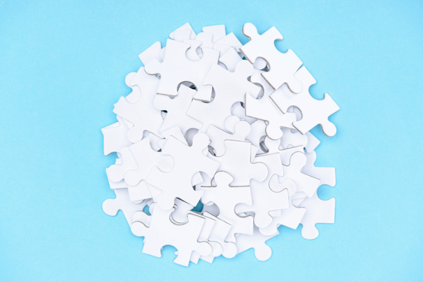 top view of arranged white puzzle elements on blue backdrop - Photo, Image