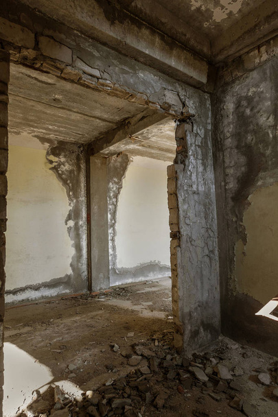 Interior de um edifício administrativo abandonado. Ruínas interiores de uma fábrica industrial. Uma escada de concreto velho, ruínas, corredor com lixo e lama, paredes arruinadas de um centro de negócios de escritório inacabado, Odessa
 - Foto, Imagem