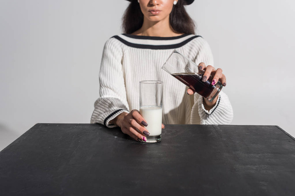 cropped image of african american girl in stylish white clothes and hat pouring soda into milk on white - Foto, Imagem