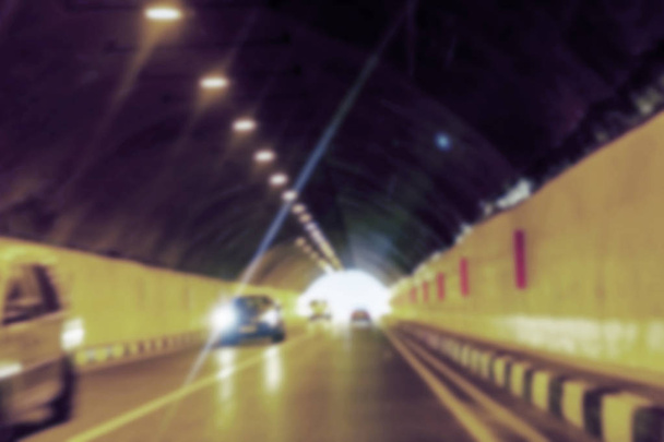 abstrakte Bewegungen verschwimmen den Hintergrund eines Straßentunnels mit fahrenden Autos und Licht am Ende. für den Einsatz als kreativer Design-Rohling. Lichtzeichen in der Tunnelbeleuchtung der Autobahn - Foto, Bild