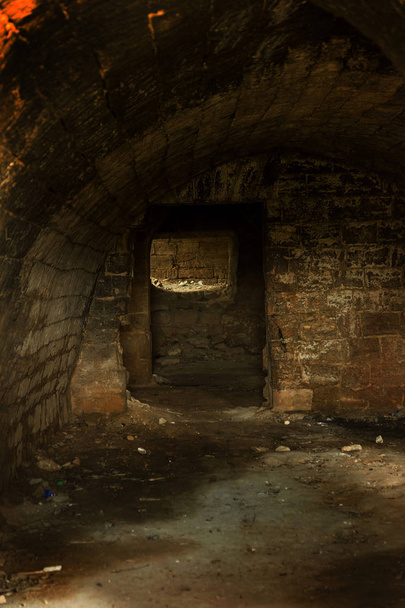 Oude verlaten tunnel in de ondergrondse wijnkelder. Ingang van de catacomben in Odessa, Oekraïne. Als een creatieve achtergrond voor een stap van donkere design. Selectieve aandacht. - Foto, afbeelding