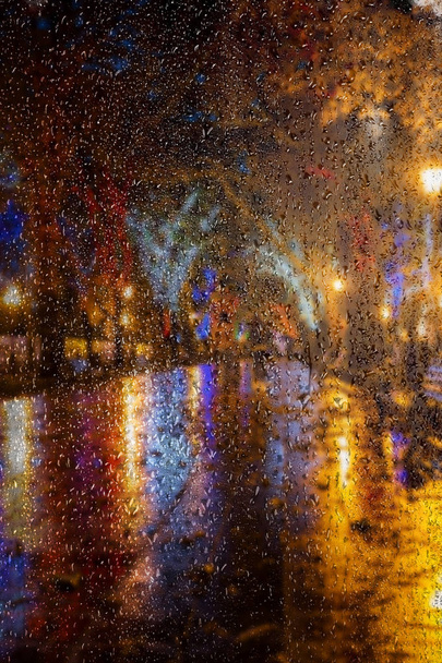 Paisaje urbano de noche borrosa. El centro antiguo de la ciudad en la noche después de la lluvia. Calle urbana nocturna con luces de colores brillantes de cafés callejeros y coches en movimiento. Desenfoque de movimiento, enfoque suave, estilización
 - Foto, Imagen