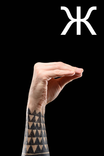 linguaggio dei segni con mano maschile tatuata e lettera cirillica, isolato su nero
 - Foto, immagini