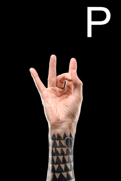 vista recortada de la mano tatuada que muestra letra cirílica, lenguaje sordo y mudo, aislado en negro
 - Foto, imagen